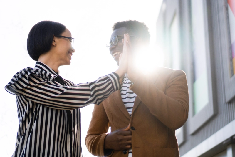 Deux collègues se félicitent en se tapant dans la main, symbole d’états financiers plus rapides et d’un pilotage renforcé en 2026